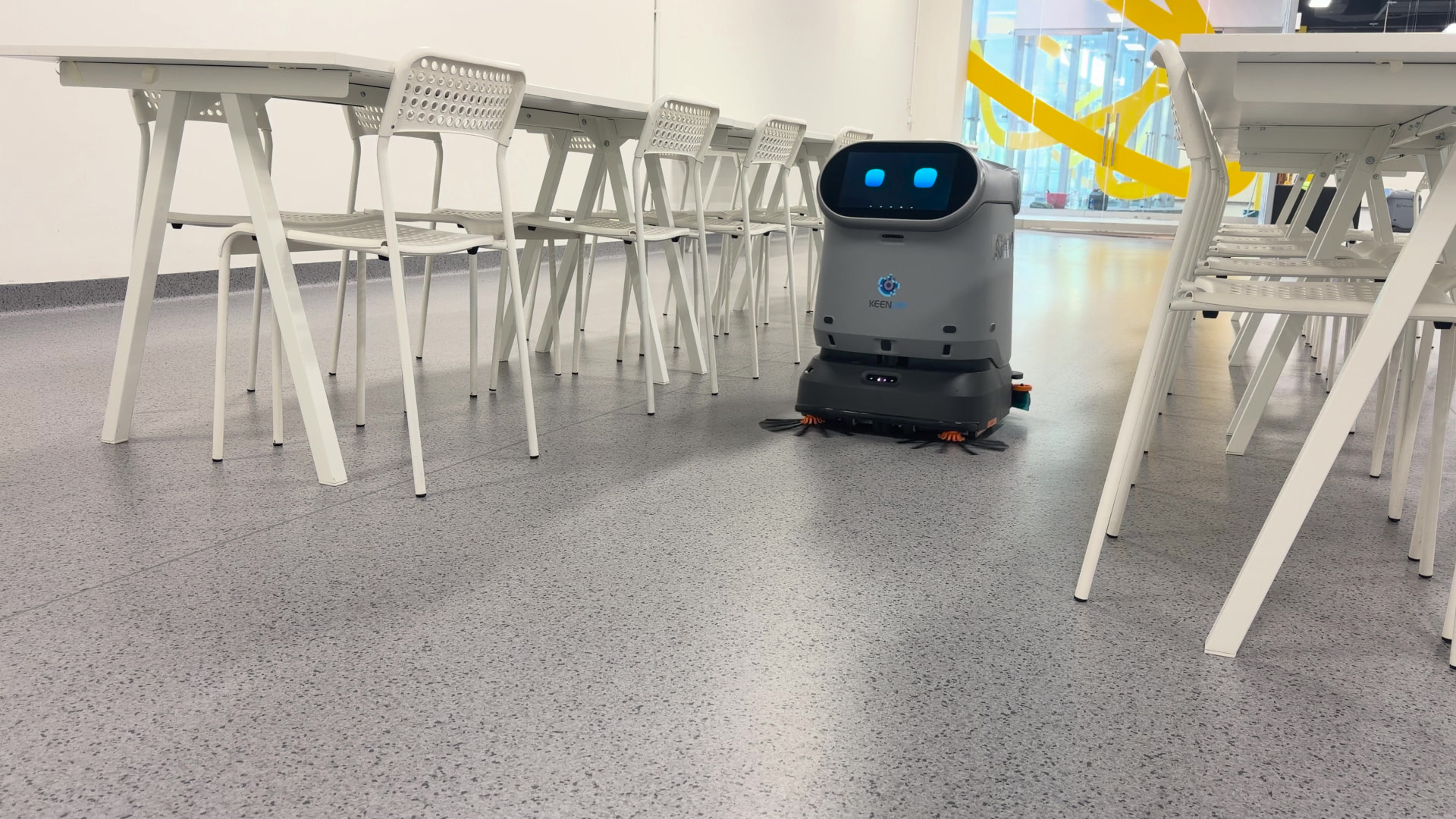 Robot KEENON C40 pri upratovaní jedálne v kancelárskej budove
